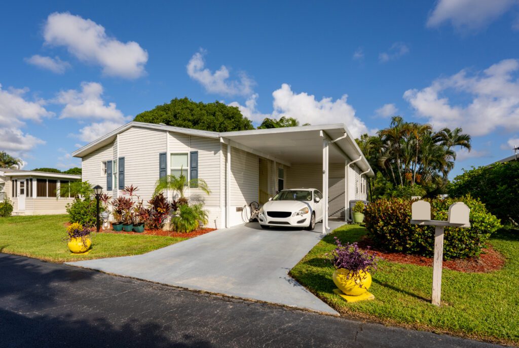 A white colored wooden house with open space for car parking